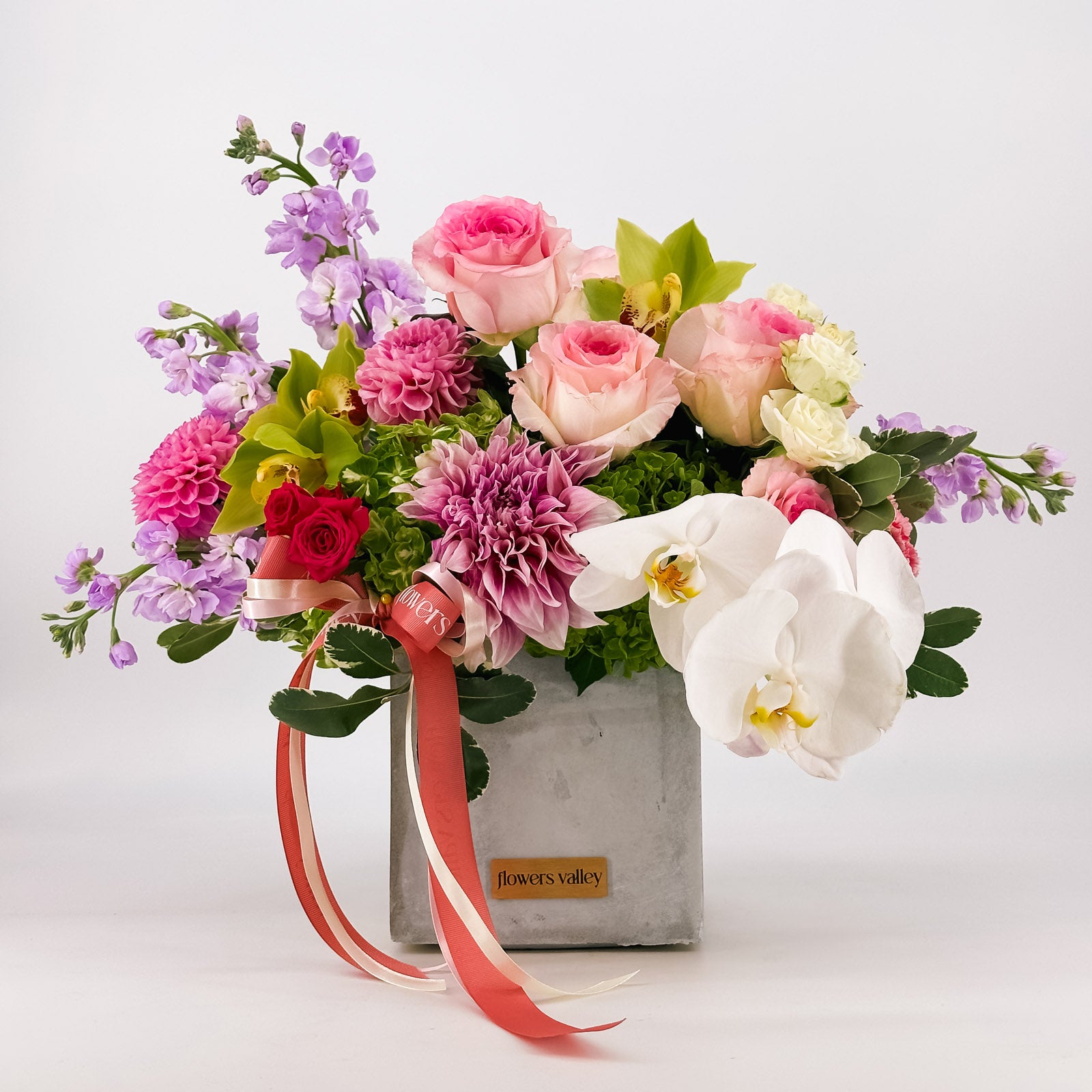 Fuchsia Garden Bloom, a vibrant pink, purple, and green floral with roses, stock, orchids, and dahlias in a concrete vase, for premium Bay Area delivery