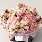 Close-up of pastel pink hydrangeas and carnations wrapped in tissue paper
