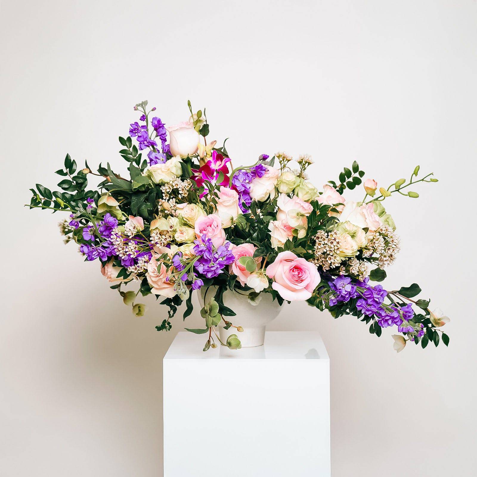 Enchanted Garden bouquet with pink and purple blooms in a sculptural vase arrangement