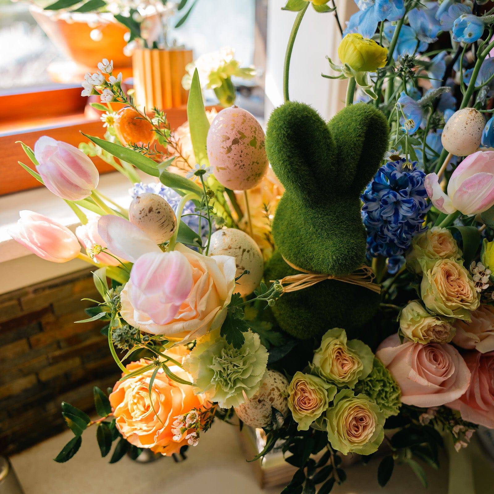 Close-up of tulips and mimosa in Easter-themed floral arrangement