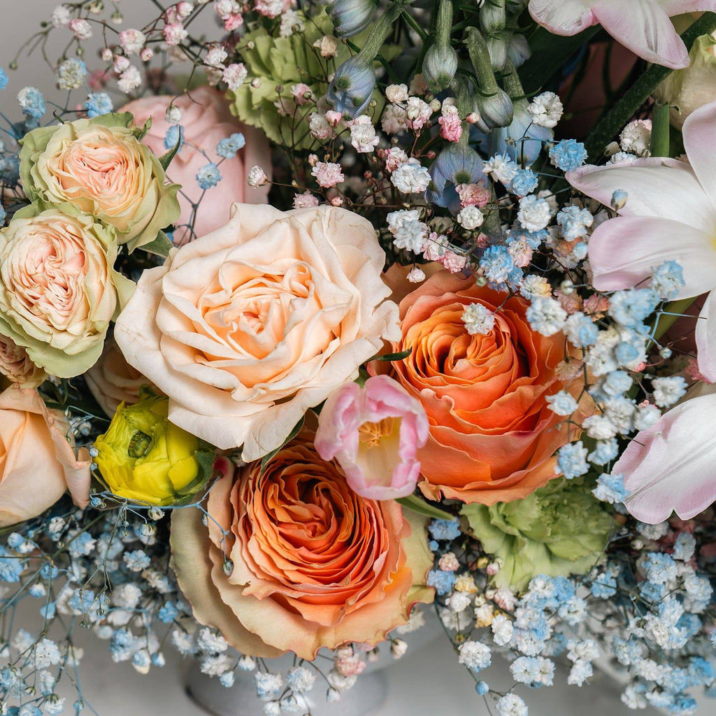 Detail of soft pink ranunculus and peach roses in Morning Bloom bouquet