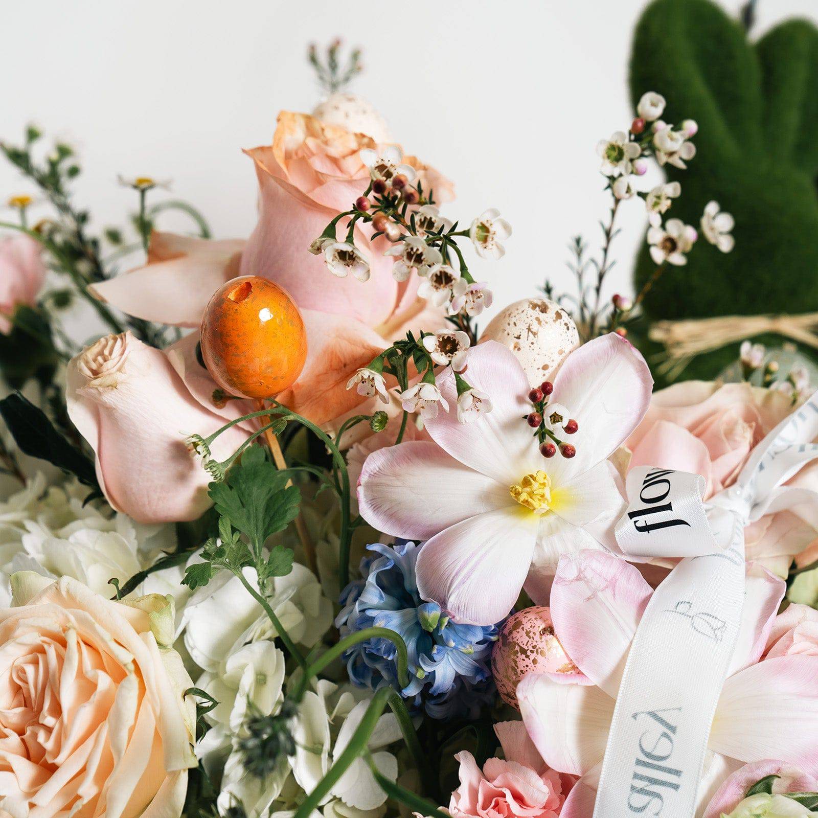 Close-up of Easter flower basket with blush roses and seasonal accents