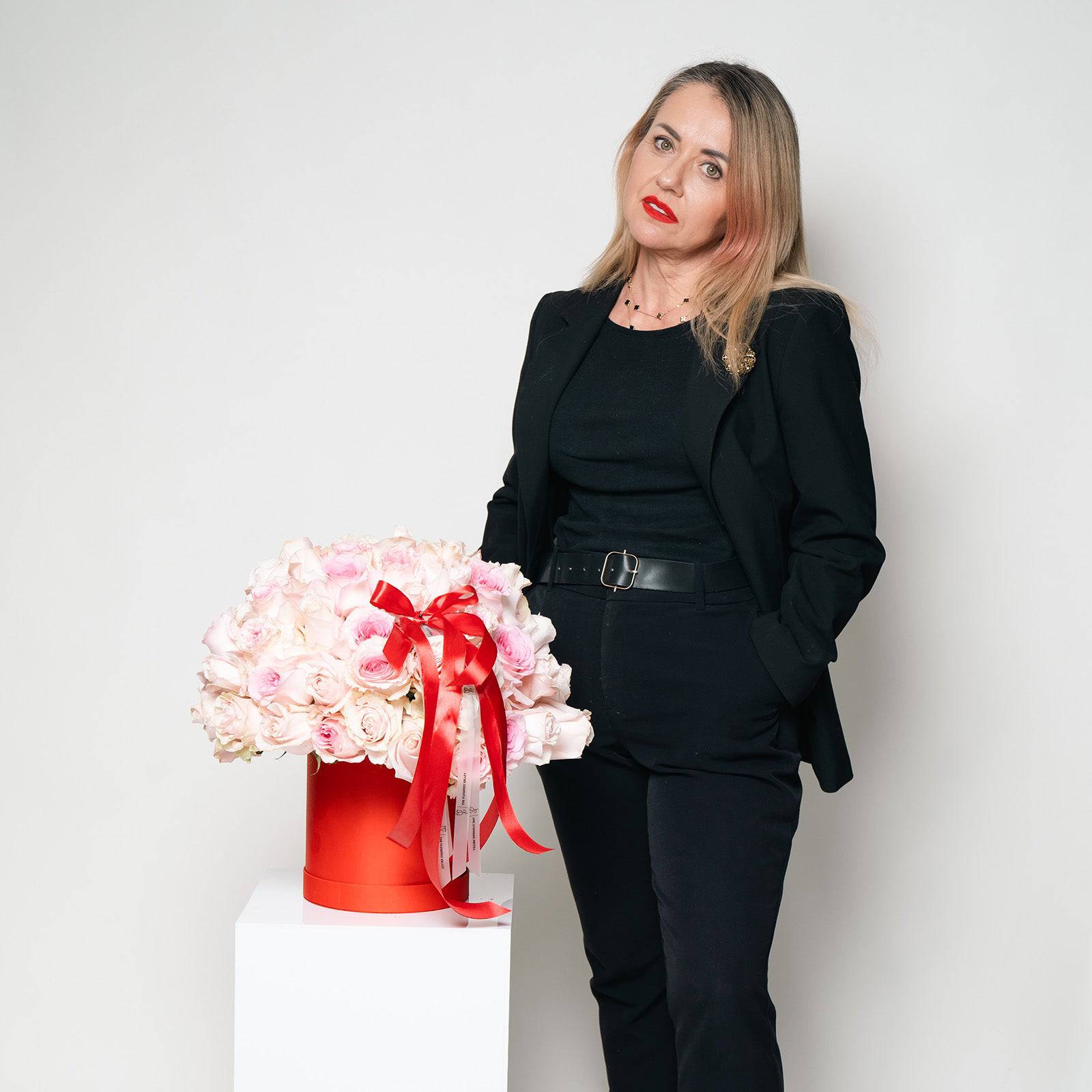 Woman holding Sweet Kiss rose bouquet in red signature box by Flowers Valley