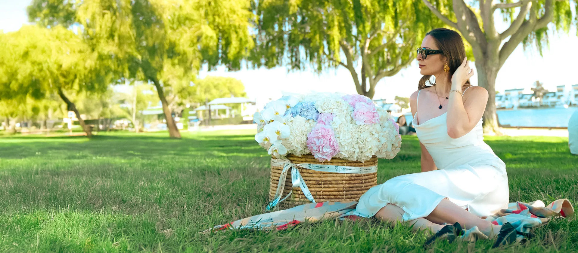 Woman in a park with a picnic basket and flowers - Flowers Valley