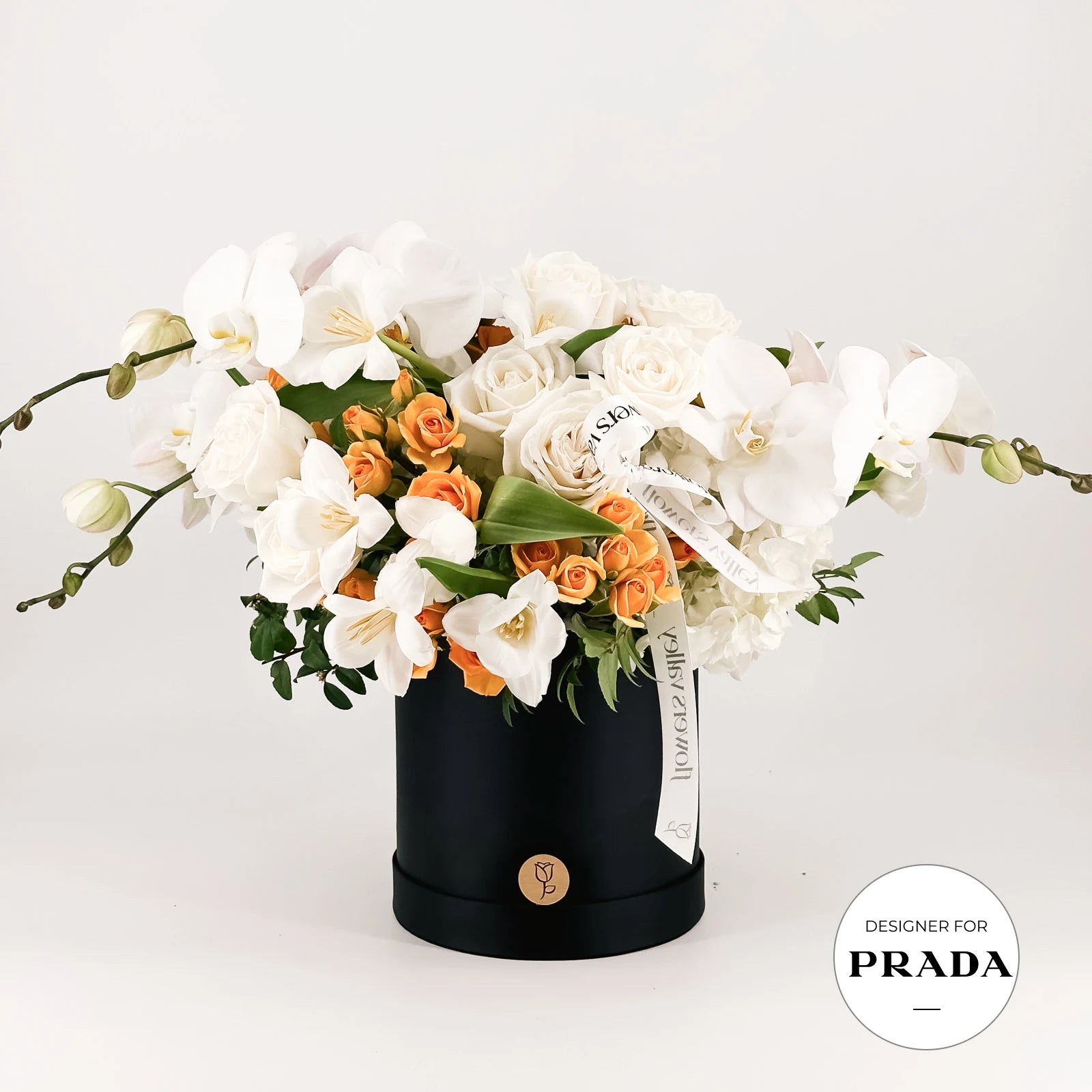 Premium floral arrangement  in a black box with 'Designer for Prada' label on a white background made by Flowers Valley
