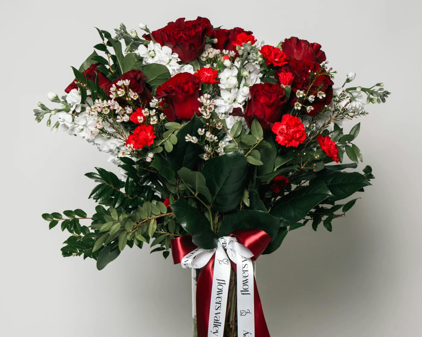 Elegant bouquet of red roses and carnations with white accent flowers and greenery, tied with red ribbon – Flowers Valley Dixon flower delivery