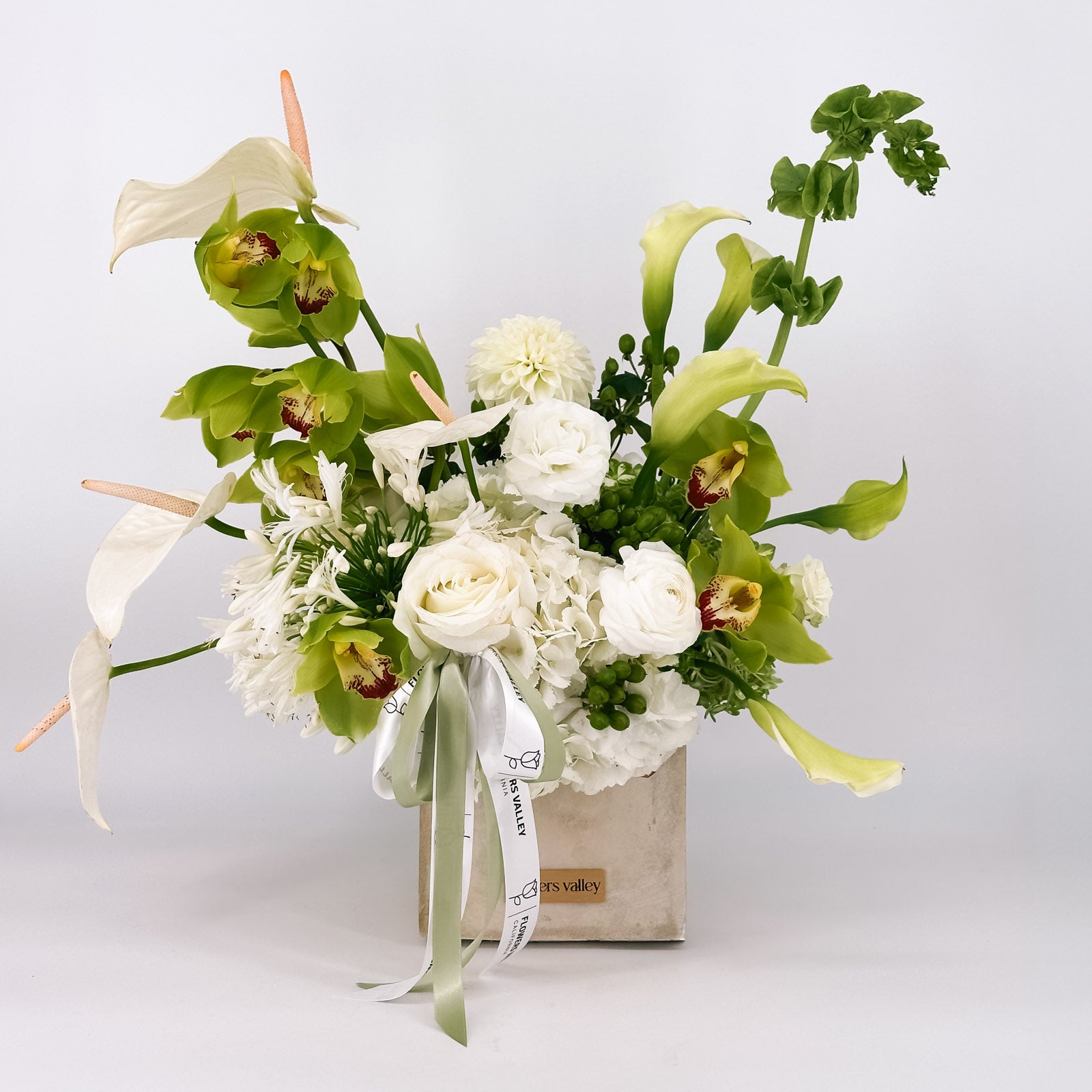 Modern white and green flower arrangement, the Urban Serenity Arrangement, in a concrete vase, available for local delivery from Flowers Valley